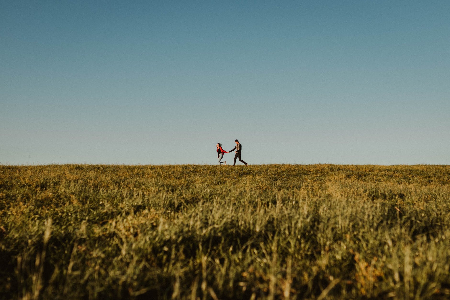 couple running happily in field